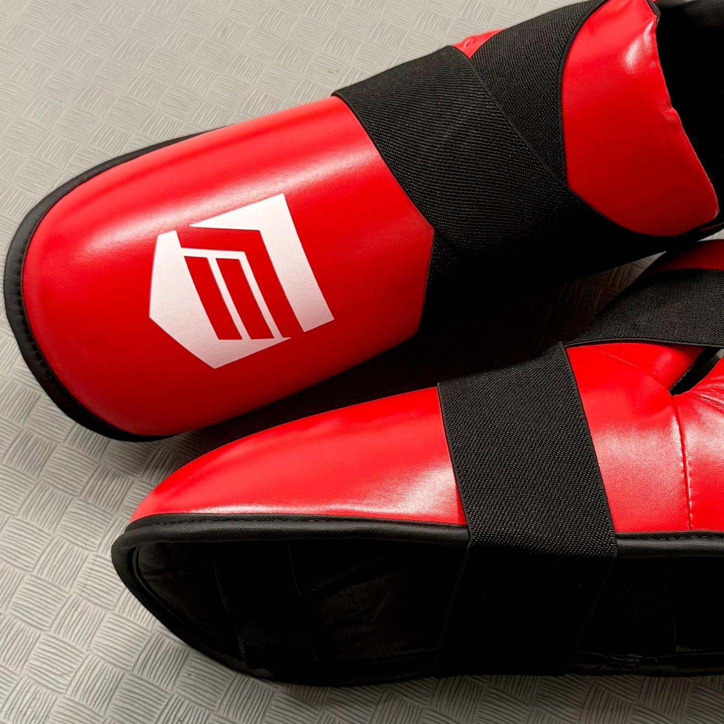 Red and black foot pads on a grey mat