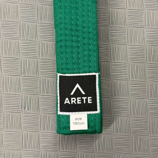 Green belt with Arete logo on a gray mat