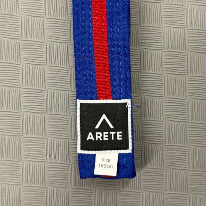 Blue and red belt with Arete label on a textured gray background