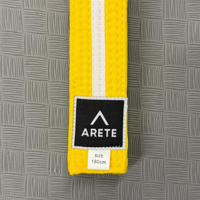 Yellow belt with a black and white label on a gray textured background