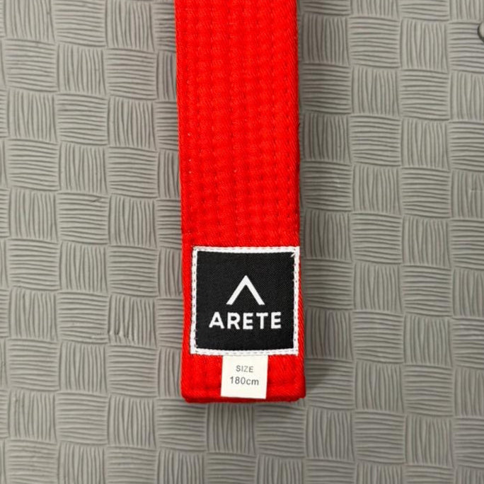 Red belt with a black label on a grey textured background