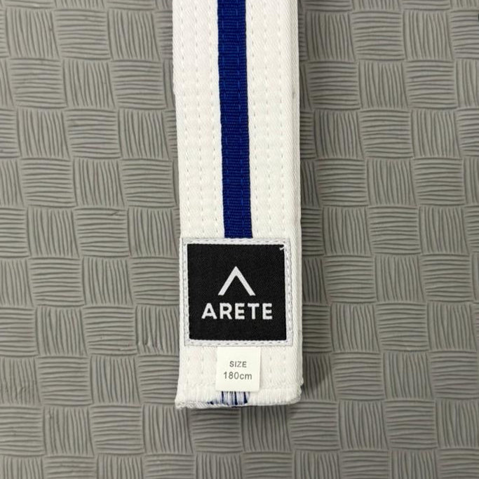 White martial arts belt with blue stripe on a gray mat background, featuring the Arete brand.