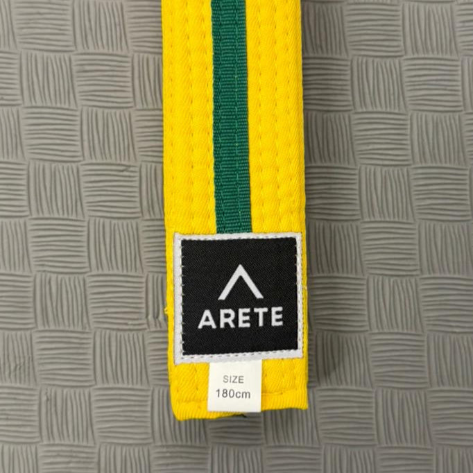 Yellow and green belt with Arete logo on a gray textured background