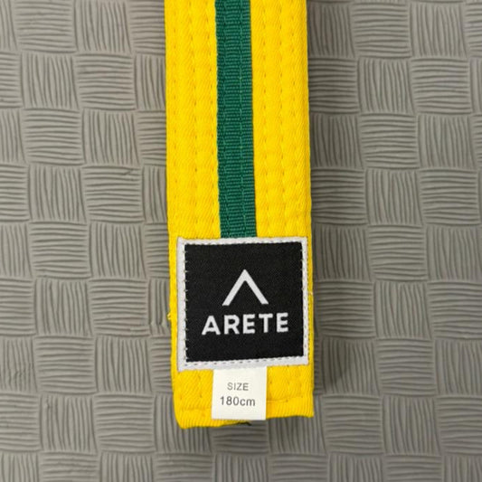 Yellow and green belt with Arete logo on a gray textured background
