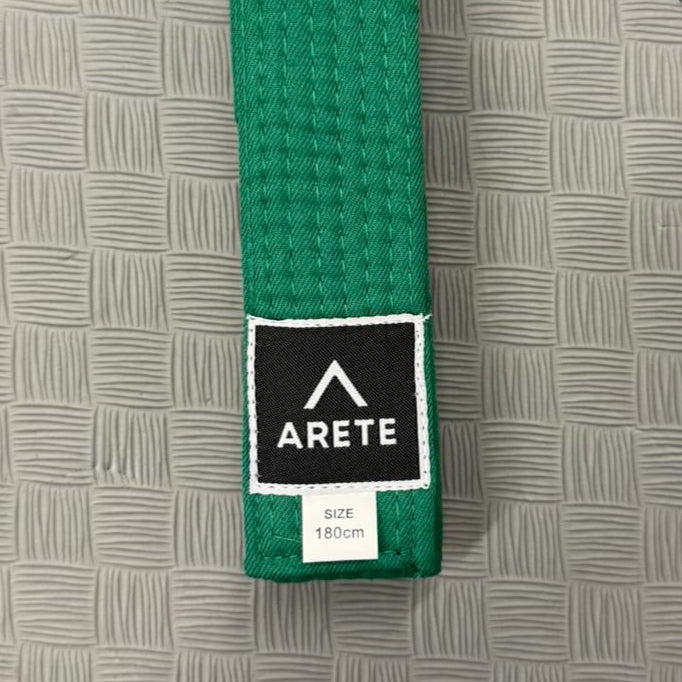 Green belt with Arete logo on a gray mat