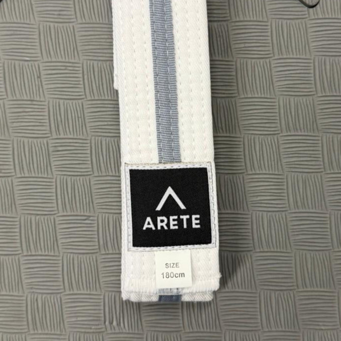 White belt with a black Arete logo on a gray textured background