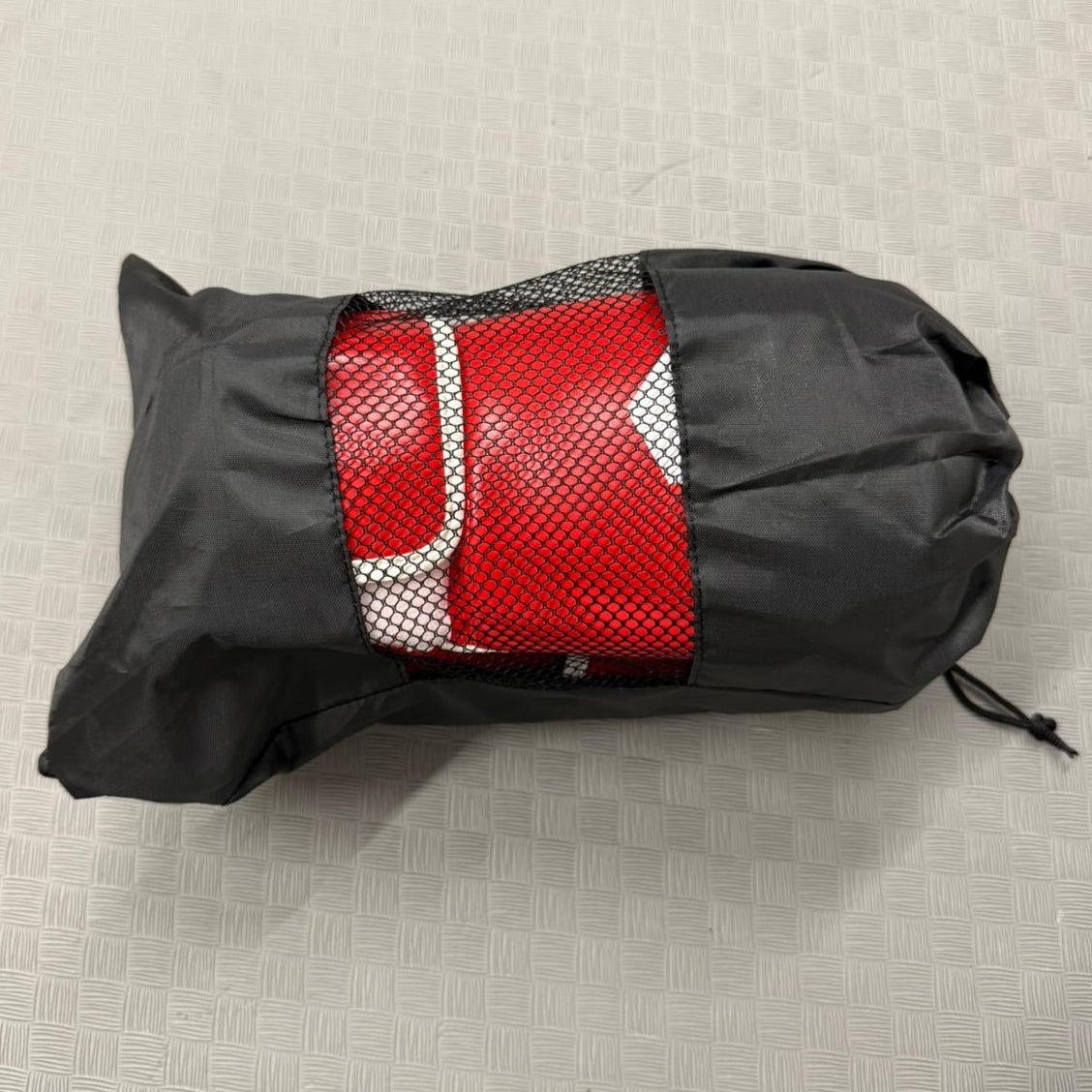Red and silver bag inside a black carrying case on a textured surface