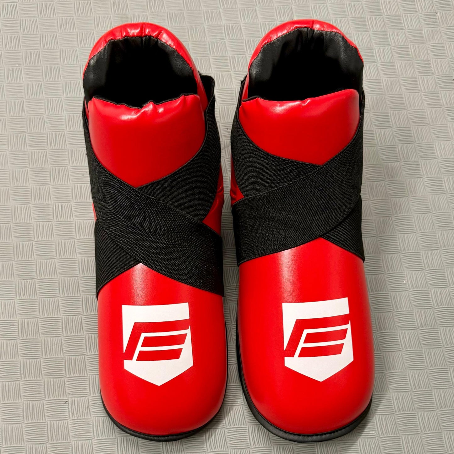 Red and black protective foot pads on a grey mat
