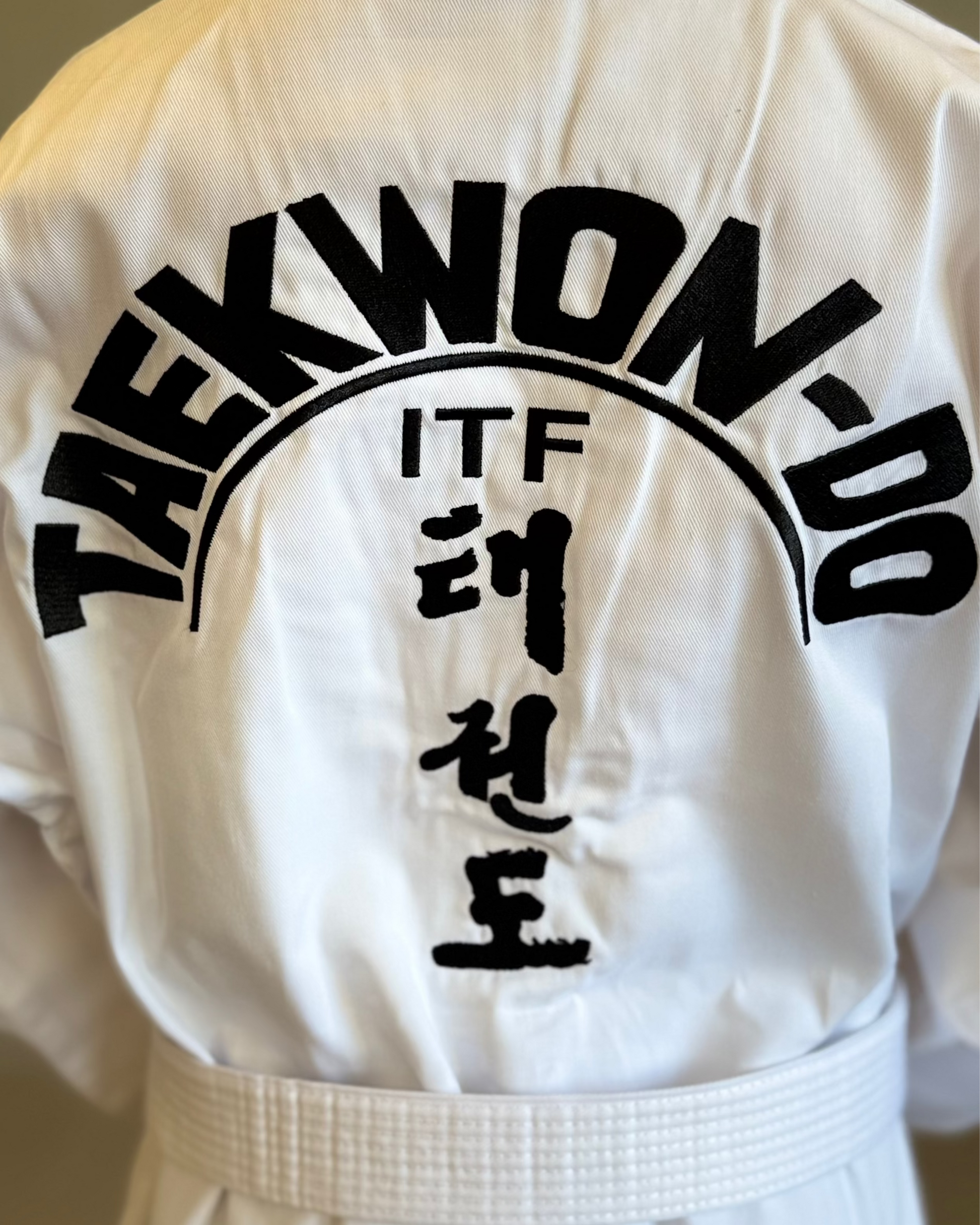 White Taekwondo uniform with 'ITF' and Korean text on the back.