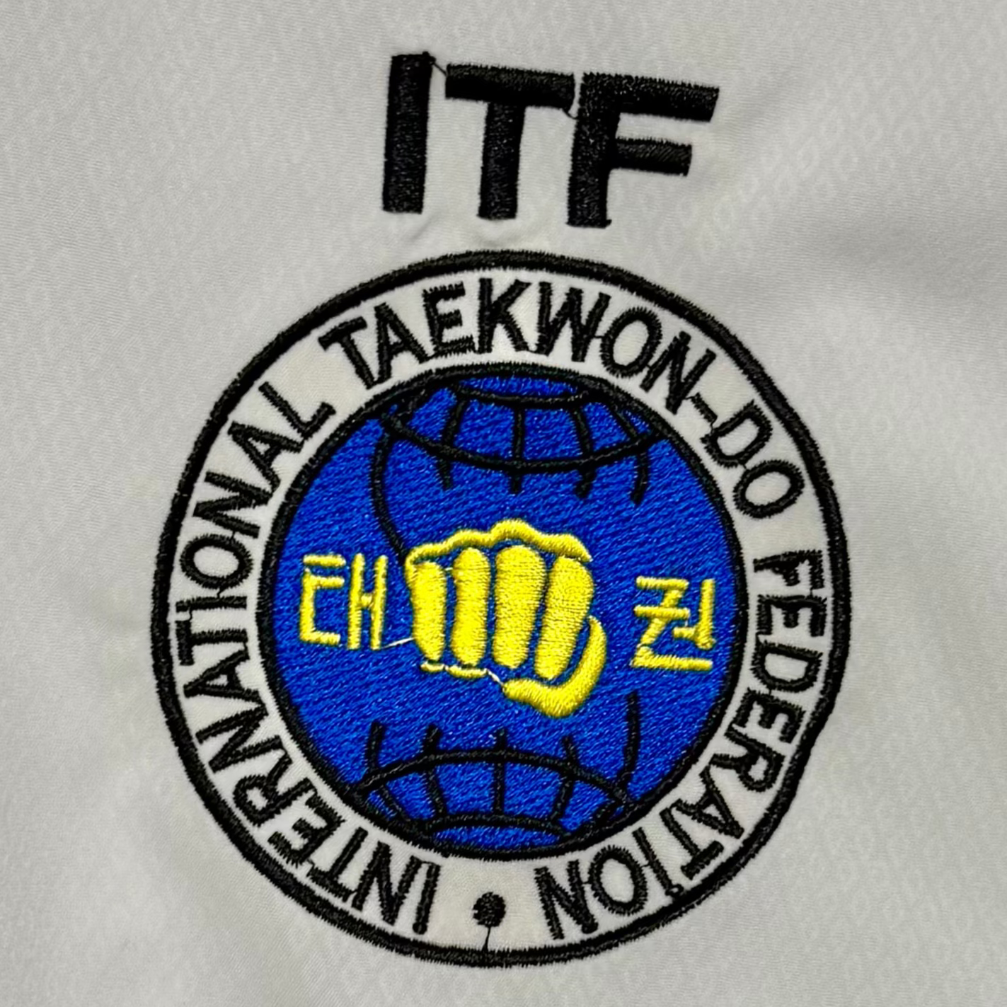 White martial arts uniform with ITF logo