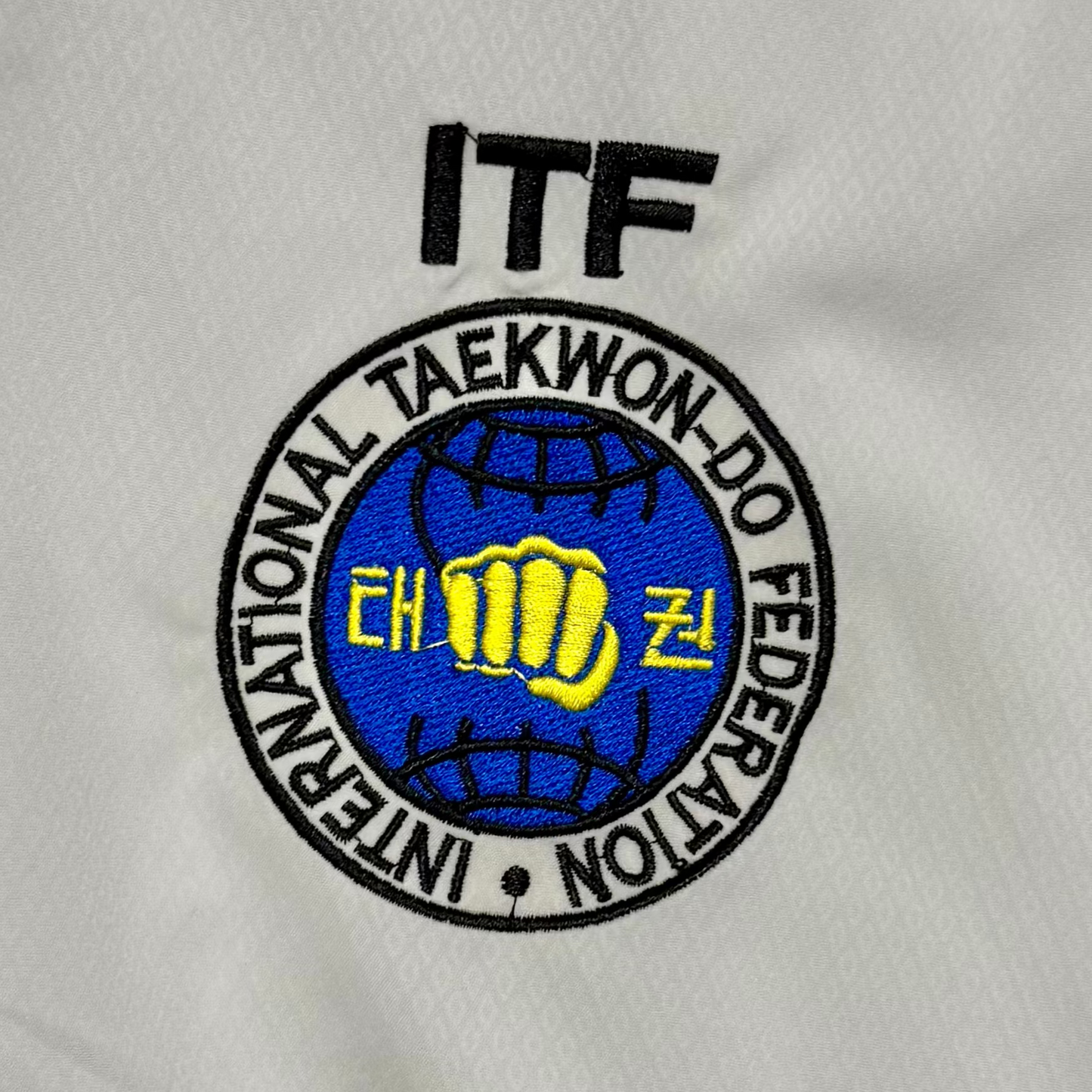 White martial arts uniform with ITF logo 