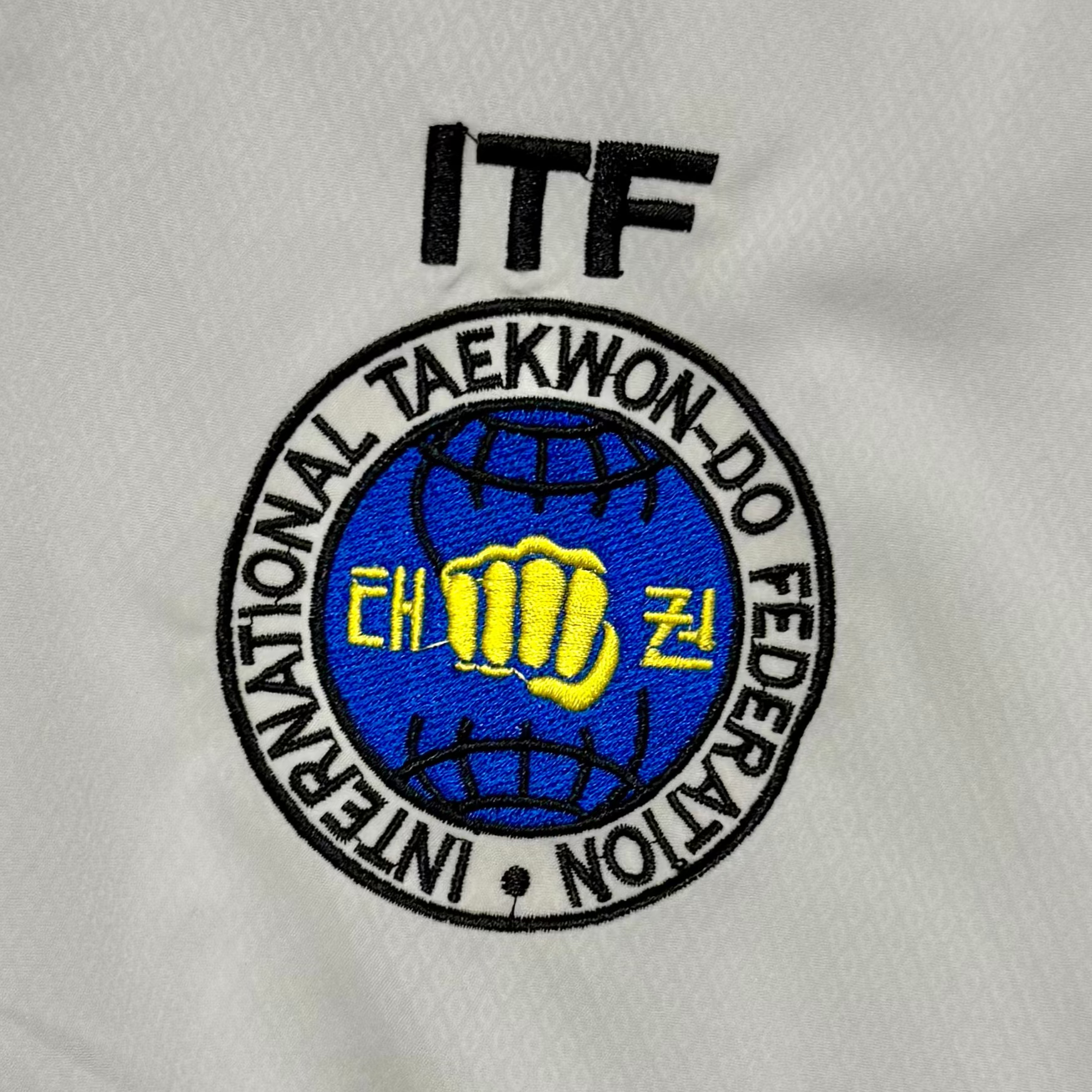 White martial arts uniform with ITF logo 