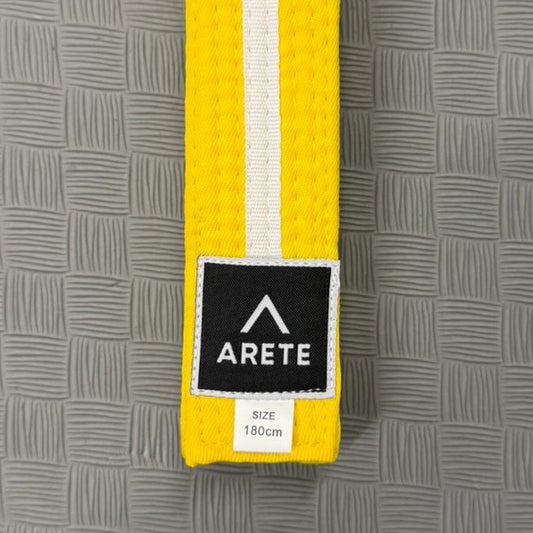 Yellow belt with a black and white label on a gray textured background