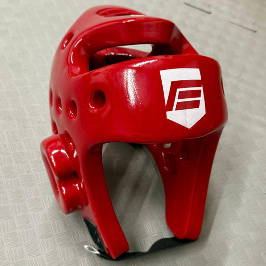 Red boxing helmet with a logo on a grey floor