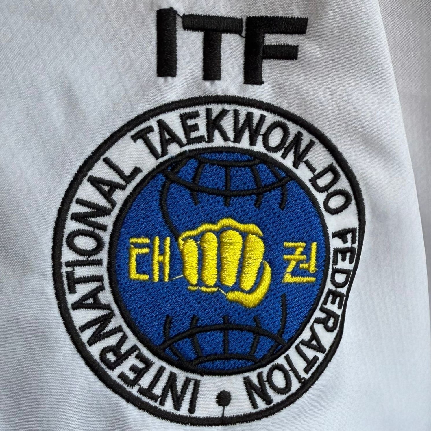 Embroidered International Taekwon-Do Federation logo on a white background