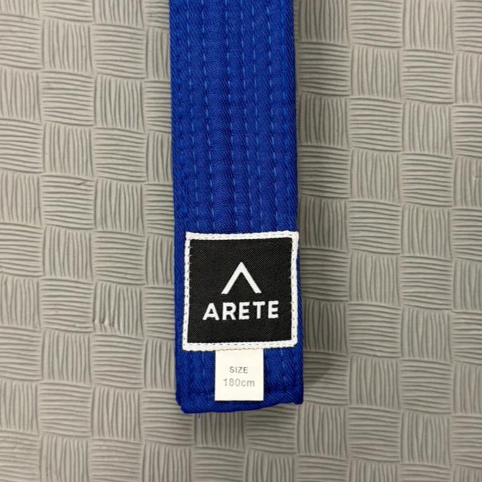 Blue belt with Arete logo on a gray textured background
